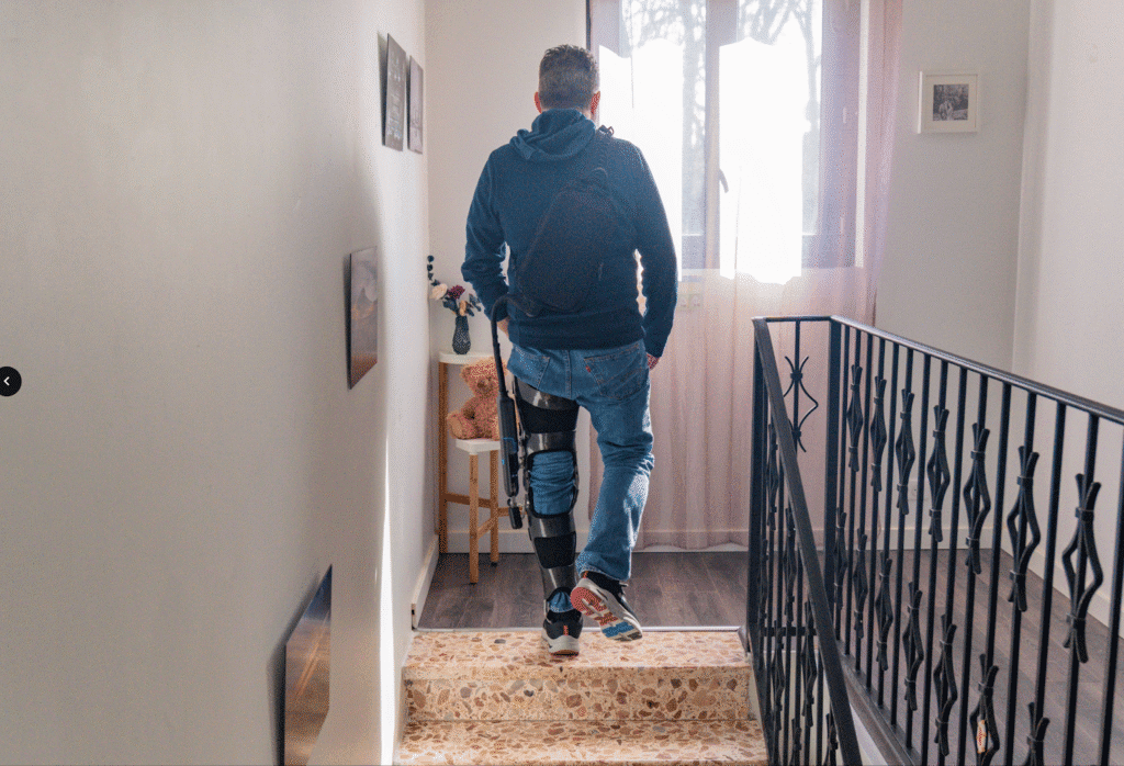Man going up the stairs while wearing a DREEVEN robotic knee brace.