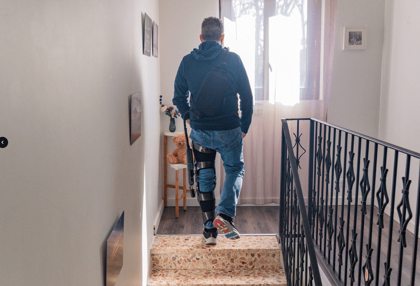 Man going up the stairs while wearing a DREEVEN robotic knee brace.